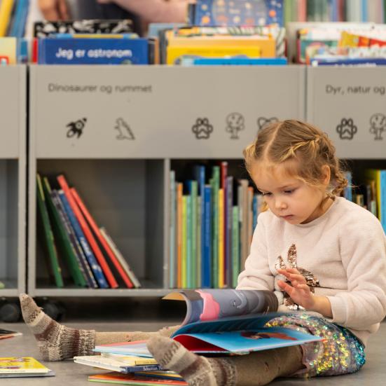 Læsende barn i biblioteket 