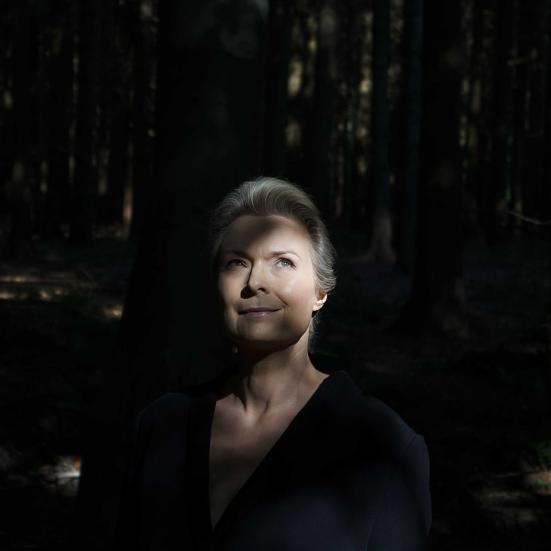 Forfatterportræt Helle Helle: står i lysningen i en skov