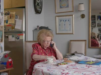 Dr. Ruth sidder ved et bord