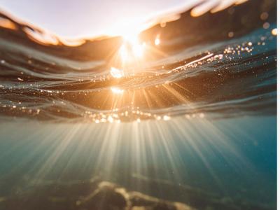 Solstråler bryder overfladen på vand